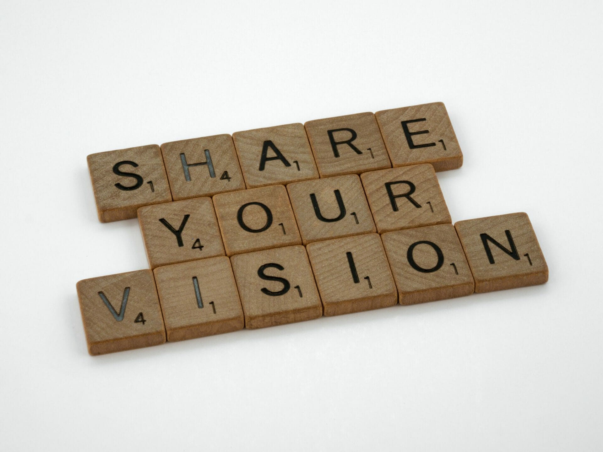 Scrabble blokjes die de tekst "SHARE YOUR VISION" laten zien.