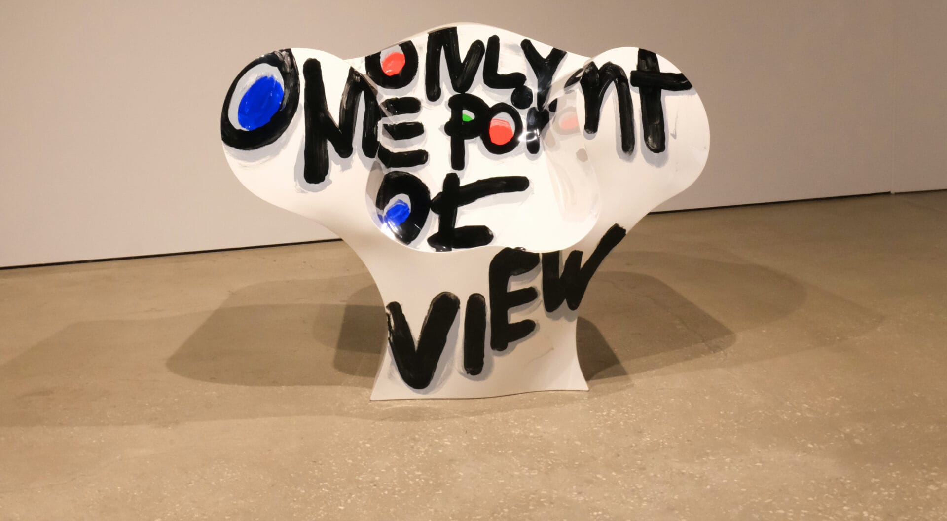 Een witte, kunststof stoel met daarop de graffiti-tekst "Only one point of view"